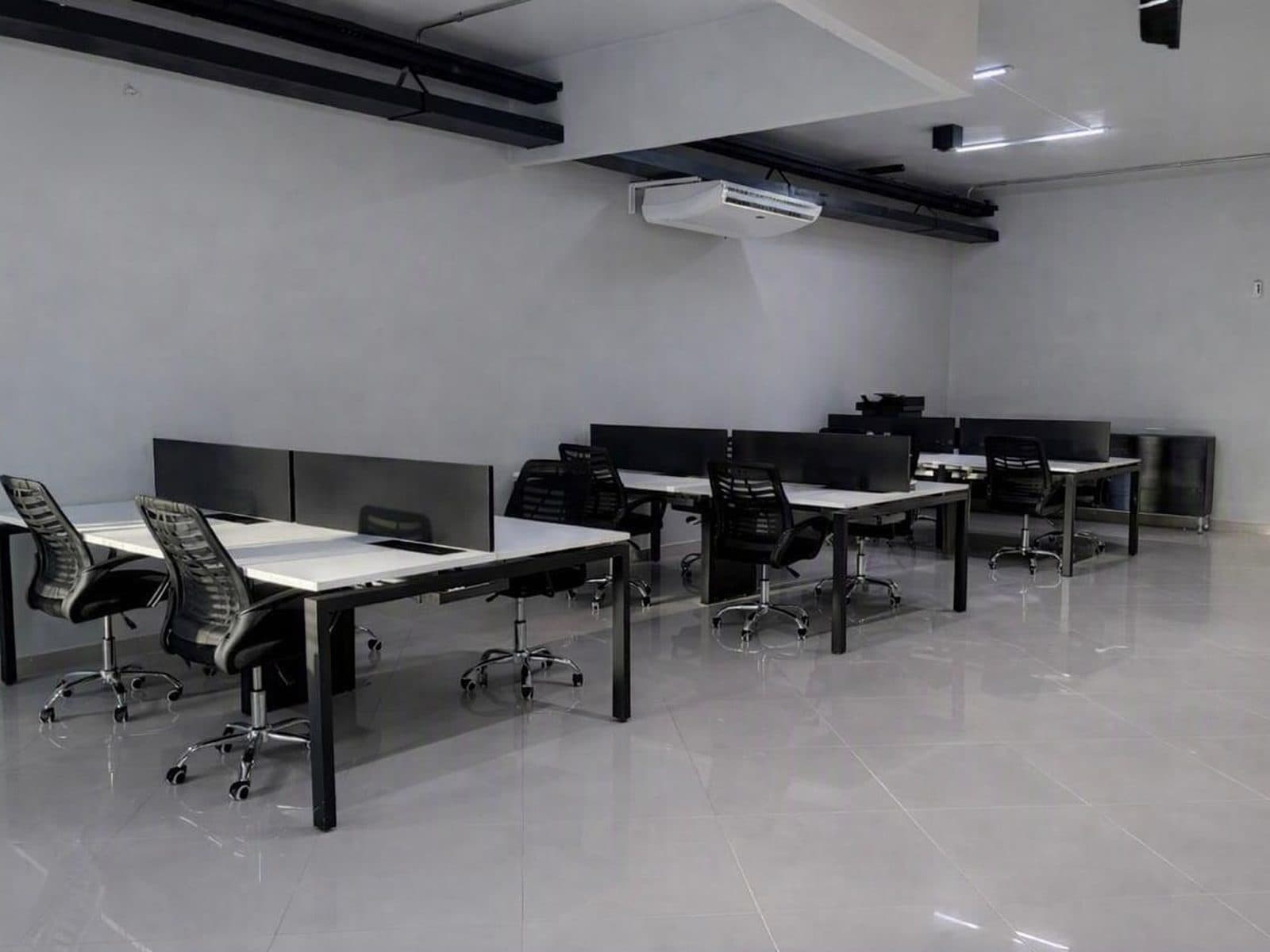 Segundo ambiente administrativo da Primmera Care, com estações de trabalho enfileiradas.