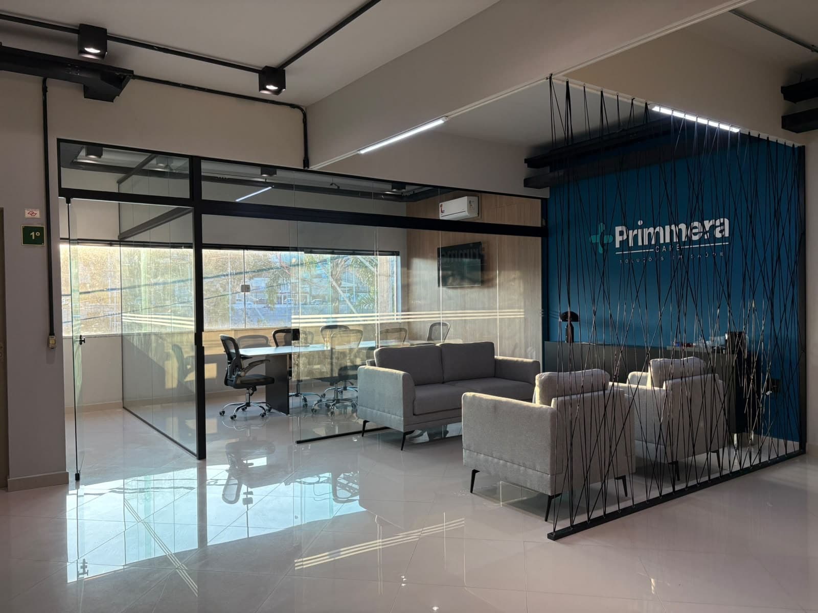 Recepção da Primmera Care com painel da marca e área de espera.