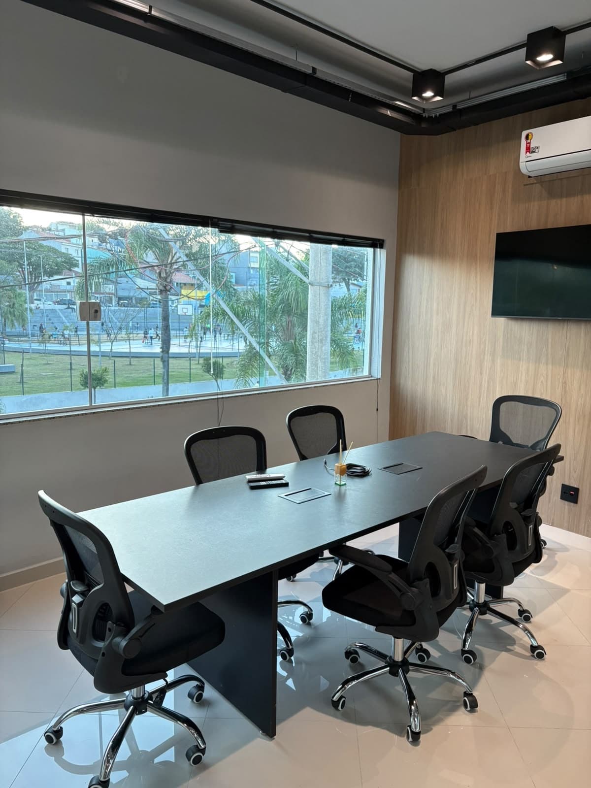 Sala de reuniões da Primmera Care, com mesa para seis lugares e televisor.